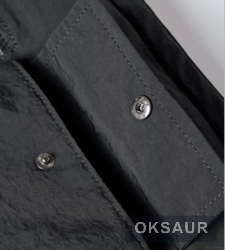 Close view of the snap-fastening front pocket on a black crossbody bag