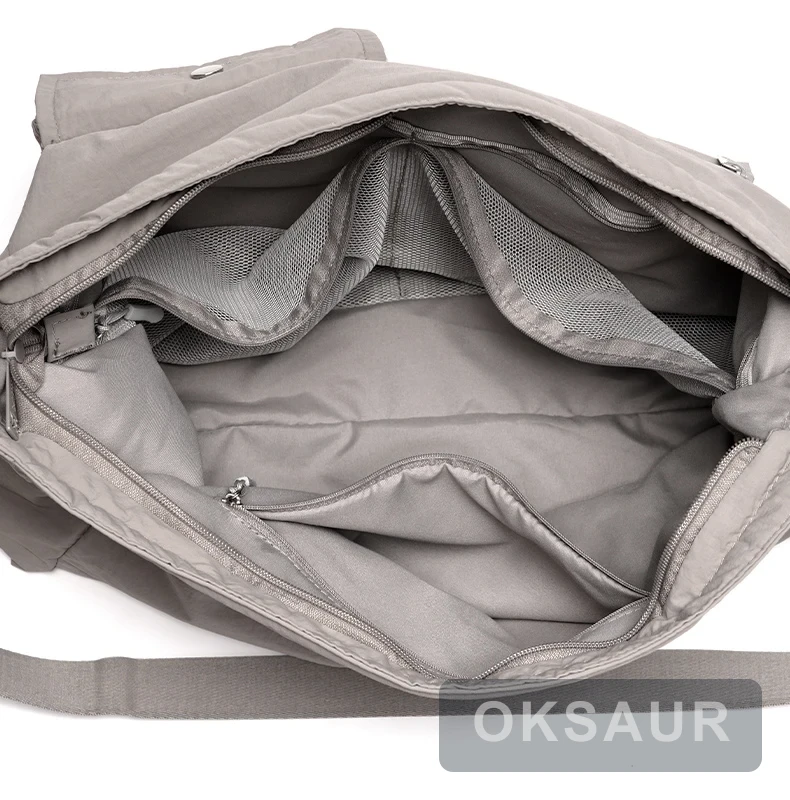 Light grey large-capacity crossbody bag showing mesh dividers and internal organizer pockets