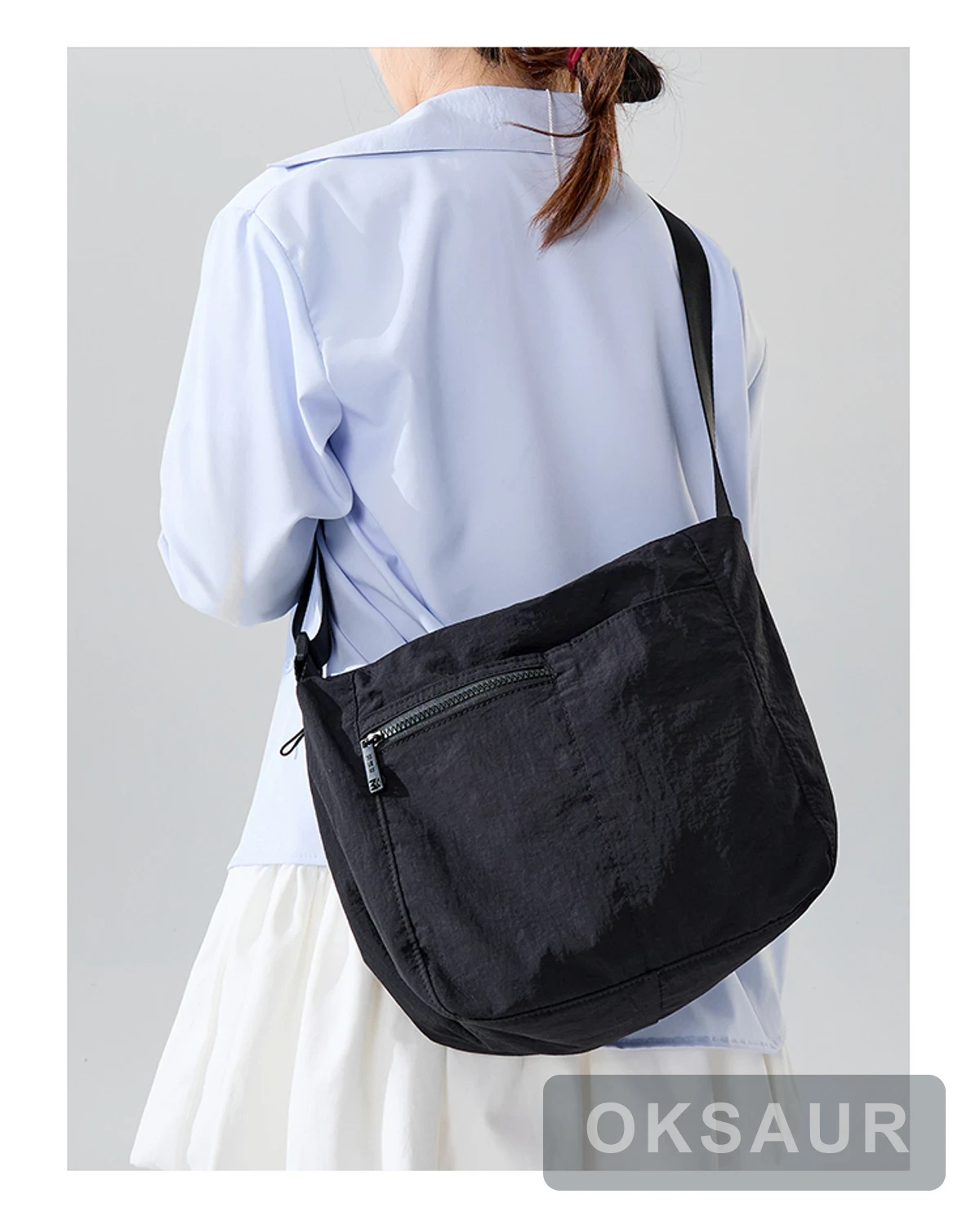 Black three-pocket crossbody bag with a rear zipper pocket