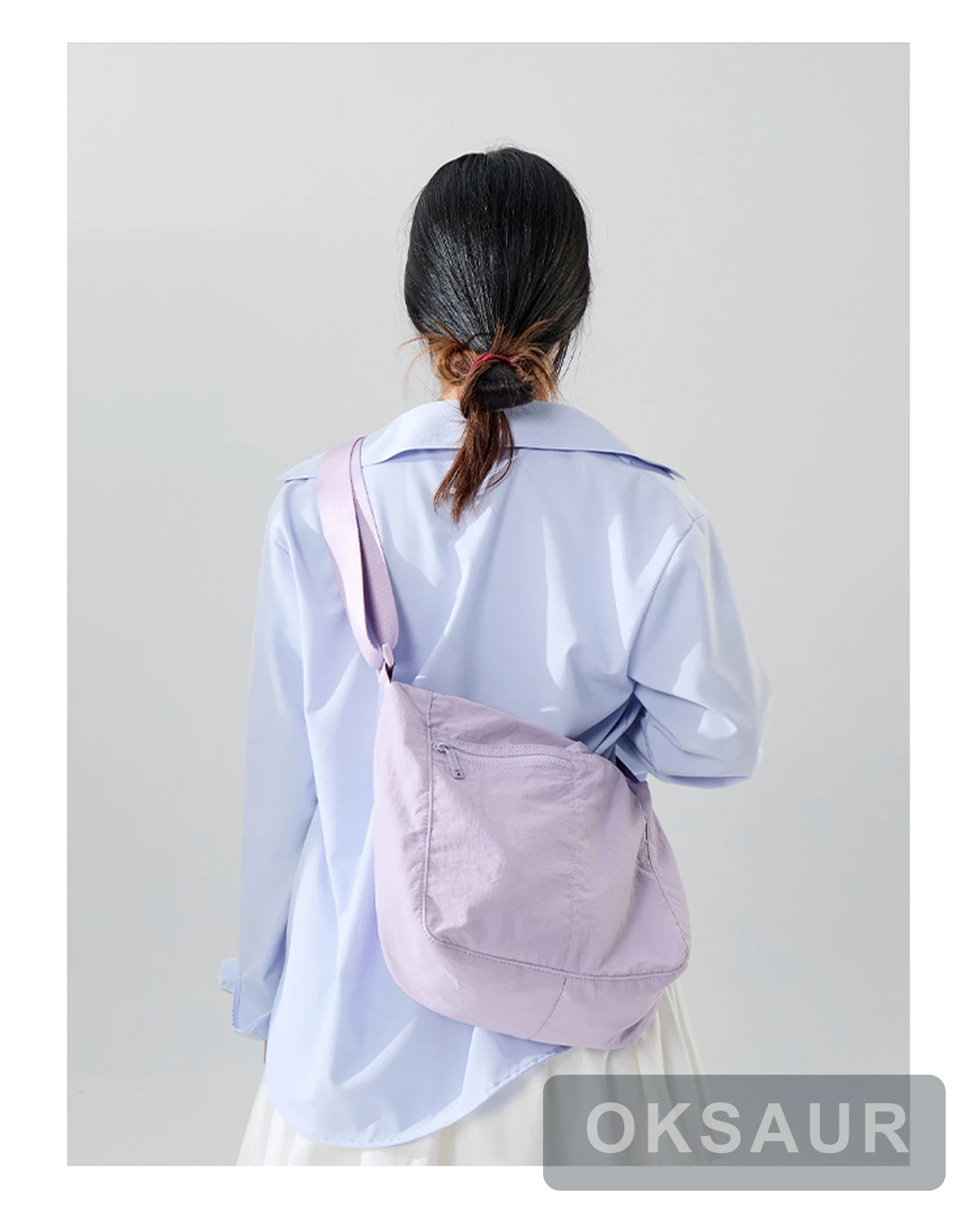 Purple three-pocket crossbody bag shown from the rear