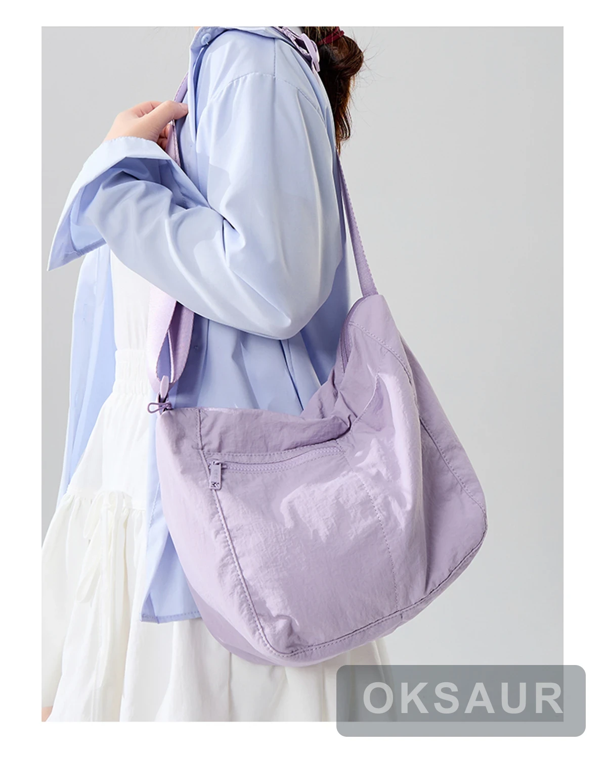 Purple three-pocket crossbody bag worn at the side