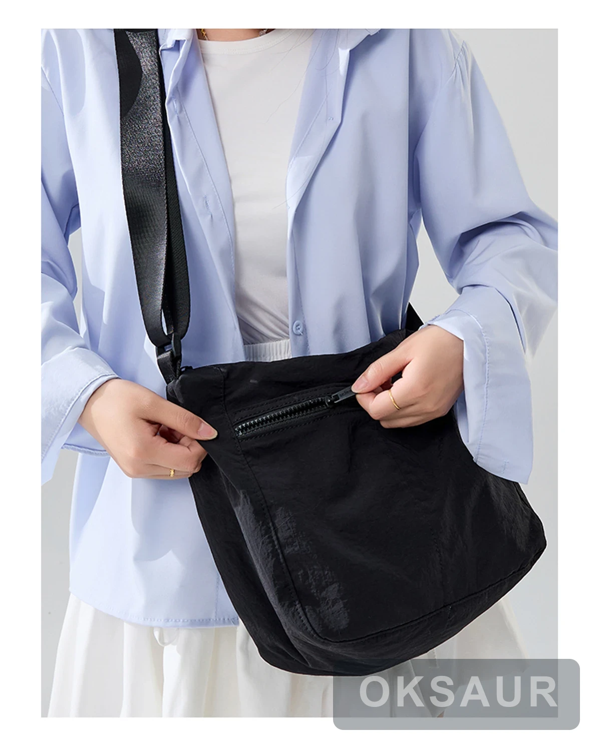 Close view of the zipper opening on a black crossbody bag