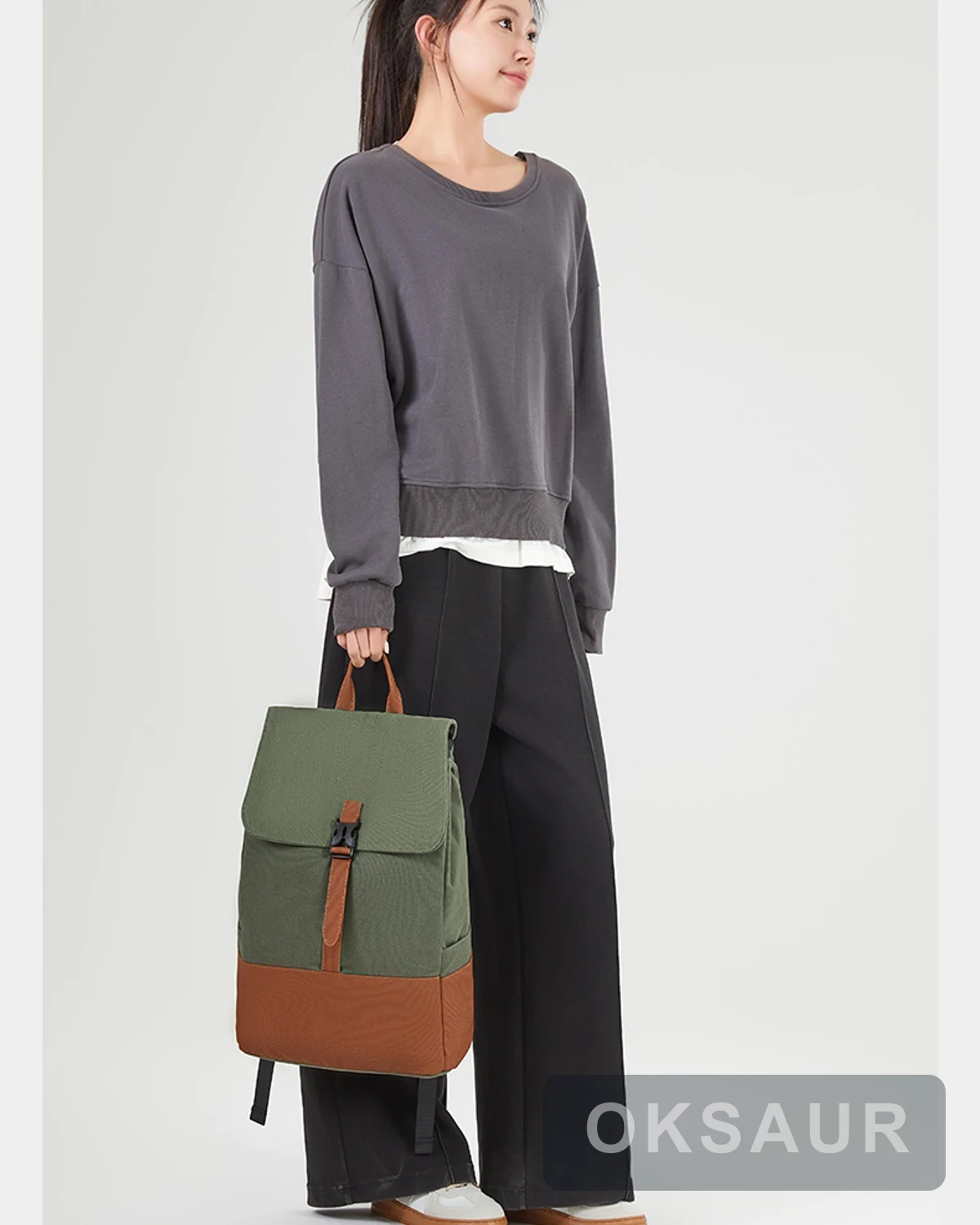 Two-tone canvas travel backpack carried by its top handle