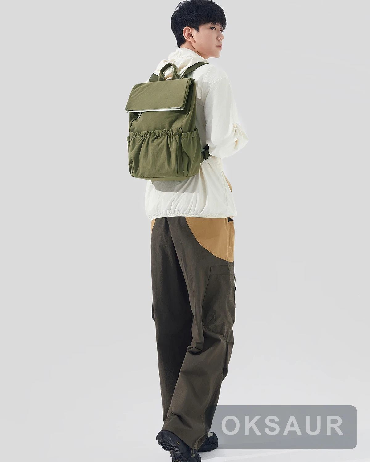 Olive pocket backpack shown from the side