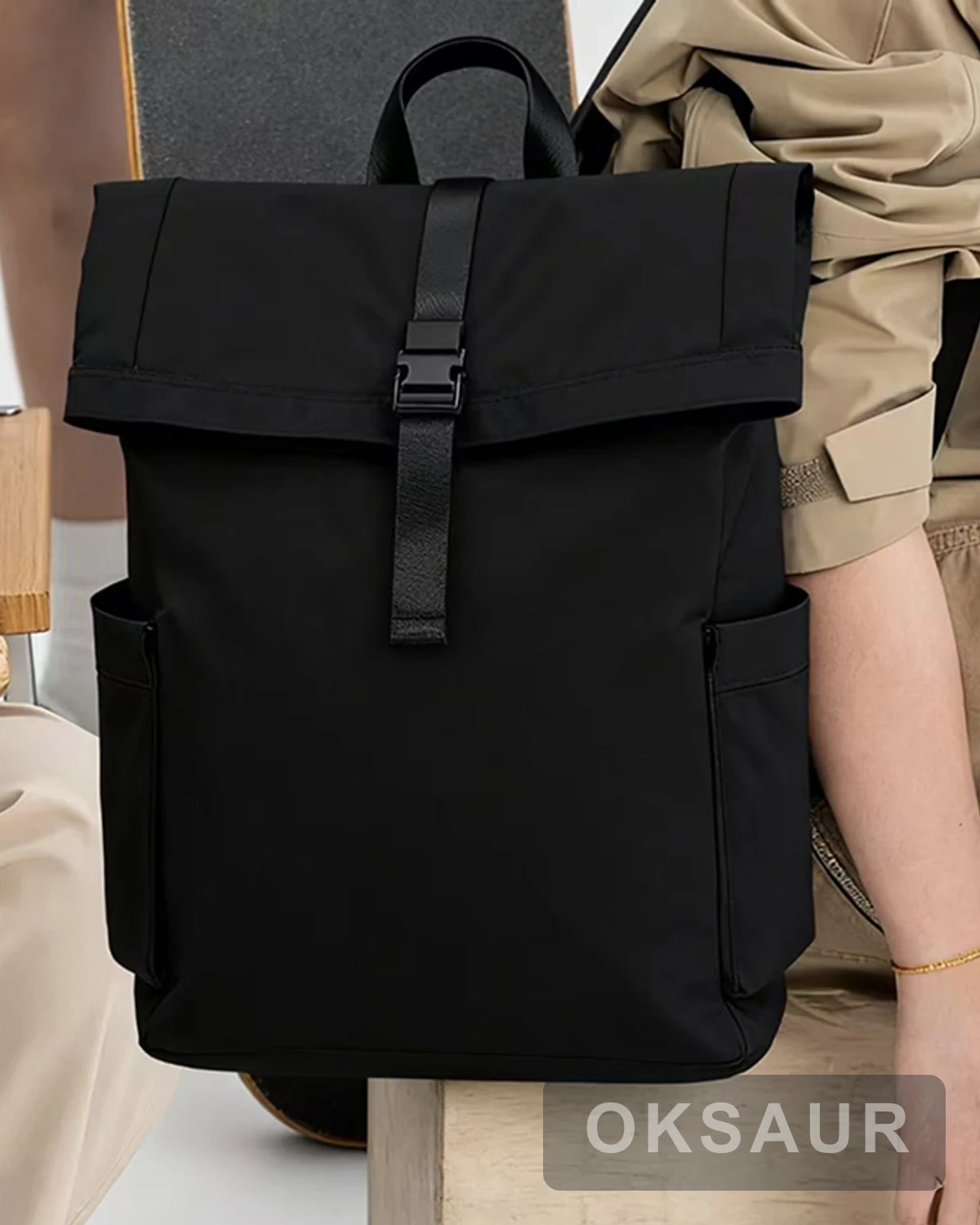 Close view of the black roll-top backpack front and buckle